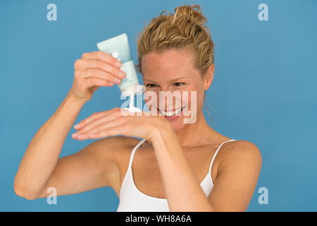 Portrait of beautiful blond woman with creme tube Stock Photo