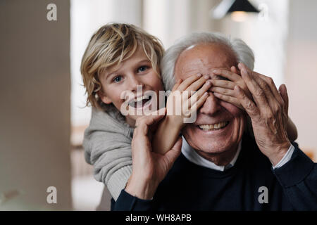 Happy grandson playing with grandfather at home Stock Photo
