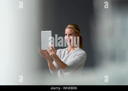 Happy young woman holding tablet Stock Photo