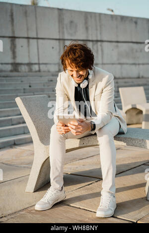 Laughing businessman using digital tablet outdoors Stock Photo