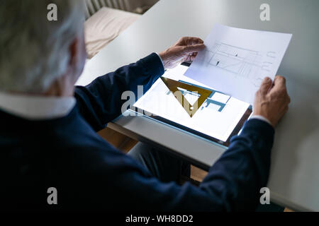 Senior man using tablet with architectural plan Stock Photo