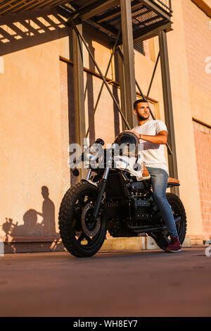 Portrait of young man sitting on his motorbike Stock Photo