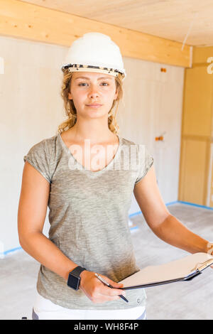 Portrait of a confident young woman in a new wooden house Stock Photo