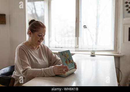 Senior woman looking in jewelry box at home Stock Photo