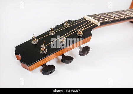 Tuning pegs on wooden machine head of six strings guitar on white background Stock Photo