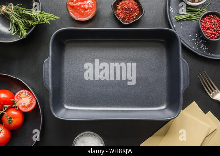 Raw ingredients for lasagna, pasta,vegetables and herbs on black background. View from above. Copy space. Restaurant cafe menu, template design. Food Stock Photo