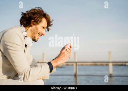 Laughing businessman using digital tablet outdoors Stock Photo