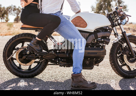 Couple sitting on motorbike, partial view Stock Photo