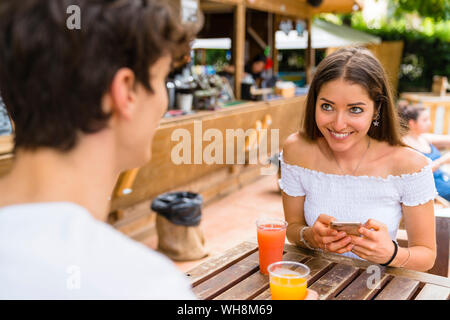 Young couple in a cafe, woman using smartphone Stock Photo