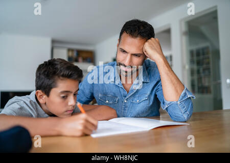 Father helping son doing homework Stock Photo