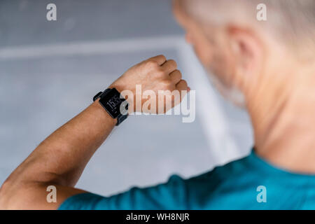 Sporty man checking his smartwatch Stock Photo