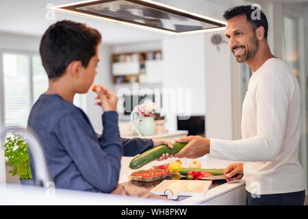 Father and son cooking in kitchen at home together Stock Photo