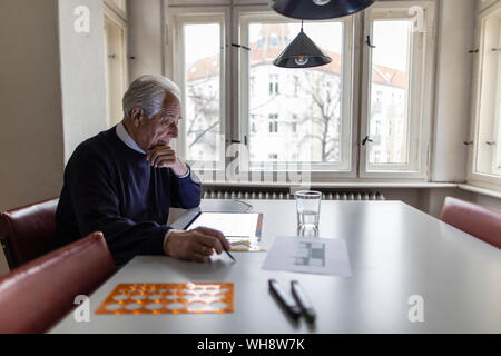 Senior man using tablet with architectural plan Stock Photo