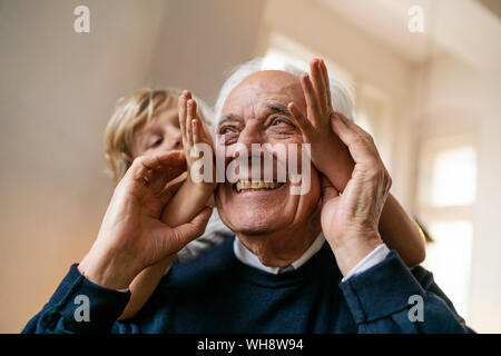 Playful grandson with grandfather at home Stock Photo