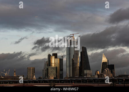 Aeroplane flying over The City of London, London, England, United Kingdom, Europe Stock Photo