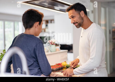 Father and son cooking in kitchen at home together Stock Photo