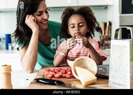 Happy mother and daughter cooking in kitchen together Stock Photo