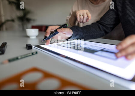 Close-up of man using tablet with architectural plan Stock Photo