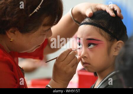 Beijing, China's Hebei Province. 20th Aug, 2019. An actress of Weishui Sixian applies make up for a kid in a kindergarten in Jingxing County of Shijiazhuang City, capital of north China's Hebei Province, Aug. 20, 2019. Credit: Zhao Danhui/Xinhua/Alamy Live News Stock Photo