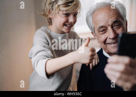 Happy grandfather and grandson taking a selfie at home Stock Photo