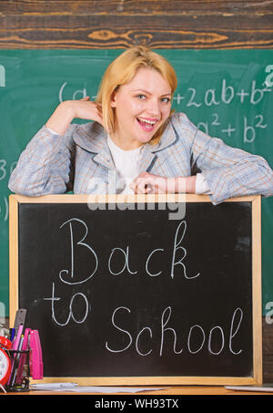 teacher with clock at blackboard. Time. Study and education. Modern school. Knowledge day. woman in classroom. School. Home schooling. happy woman. Back to school. Teachers day. Preparing to exams. Stock Photo