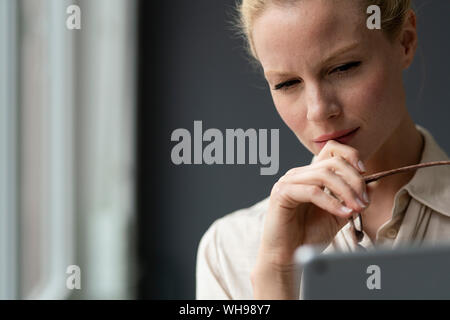 Portait of focused young businesswoman using tablet Stock Photo