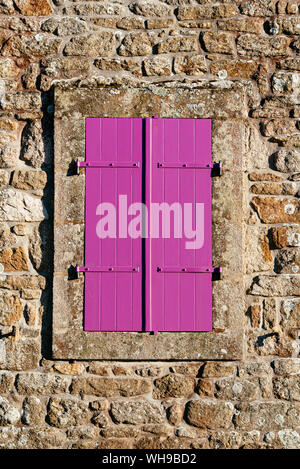 Old purple closed window in stone wall. Retro style Stock Photo