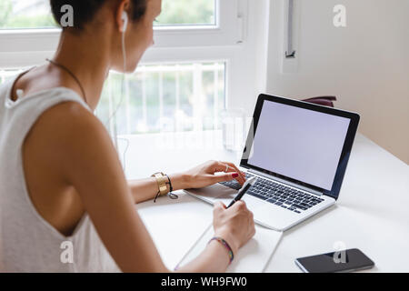 Young woman studying with her laptop at home Stock Photo