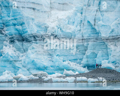 Hikers in front of Lamplugh Glacier, Glacier Bay National Park and Preserve, UNESCO World Heritage Site, Alaska, United States of America Stock Photo