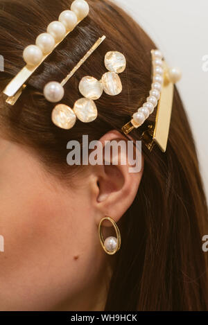 Stylish hairpins for a dark-haired girl. Pearl Earrings Stock Photo