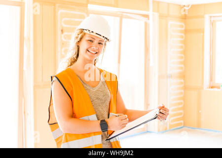 Portrait of a smiling young woman in a new wooden house Stock Photo