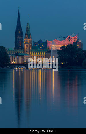 View from the Outer Alster Lake to the Elbphilharmonie, the town hall and St. Nikolai Memorial at dusk, Hamburg, Germany, Europe Stock Photo