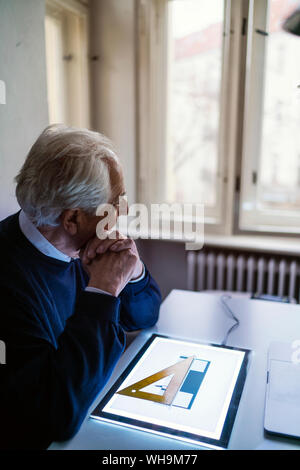 Senior man using tablet with architectural plan Stock Photo
