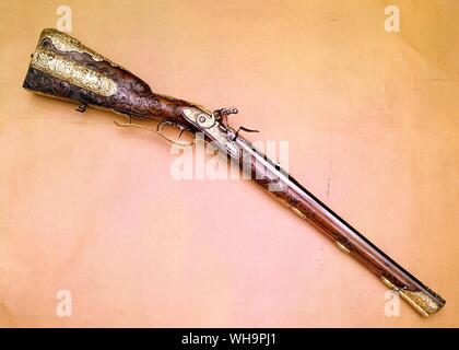 Flintlock rifle one of a pair made for the Elector Charles Albert of Bavaria later Emperor Charles VII, The mounts of gilt cooper and silver decorated with scenes from his life with his portrait bust. His monogram is inlaid in silver on the barrel Stock Photo