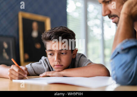 Father helping his son doing homework in classroom Stock Photo - Alamy