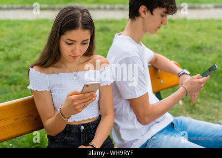 Young couple using smartphone in a park Stock Photo