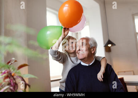Happy grandfather and grandson playing with balloons at home Stock Photo