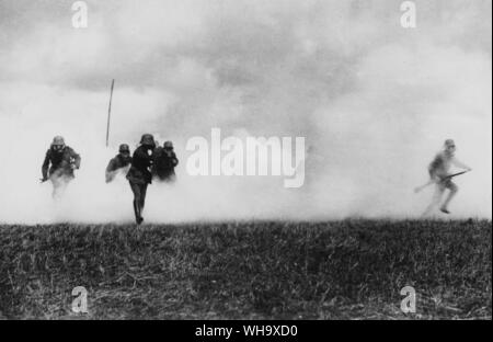 WW1: German troops in gas masks, making an assault, supported by a gas cloud. Western Front. Stock Photo