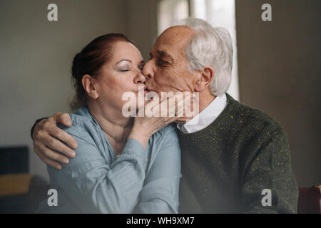 Senior couple kissing at home Stock Photo