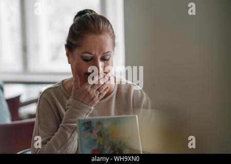 Happy senior woman looking in jewelry box at home Stock Photo