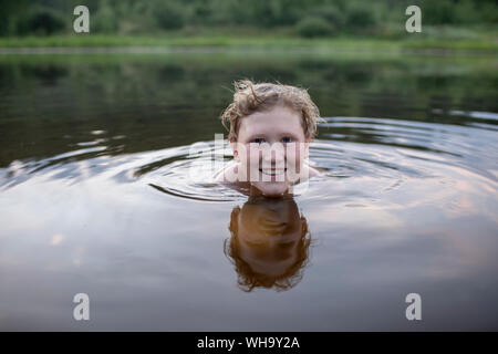 Portrait of smiling boy swimming in a lake