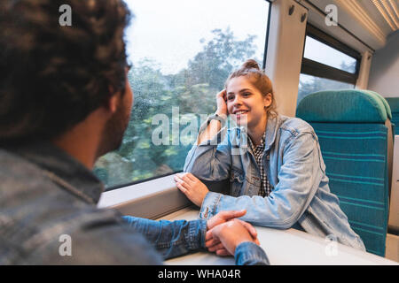 Portrait of smiling young woman travelling by train with her boyfriend, London, UK Stock Photo