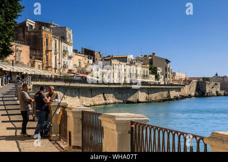 Fishermen deep in discussion, waterfront, Ortigia (Ortygia), Syracuse (Siracusa), UNESCO World Heritage Site, Sicily, Italy, Mediterranean, Europe Stock Photo