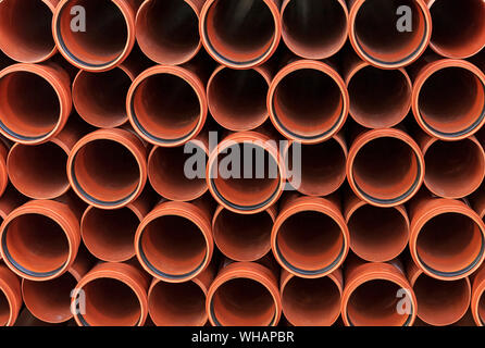 Orange sewer pipes. Background from plastic pipes. Stock Photo