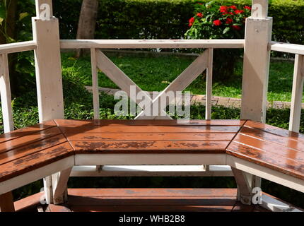 Empty couch of old wooden pavilion in garden under sunlight Stock Photo