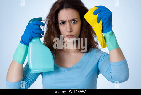 Angry and upset woman with cleaning spray and cloth cleaning feeling frustrated. The stain will not come out. In domestic duties and cleaning products Stock Photo