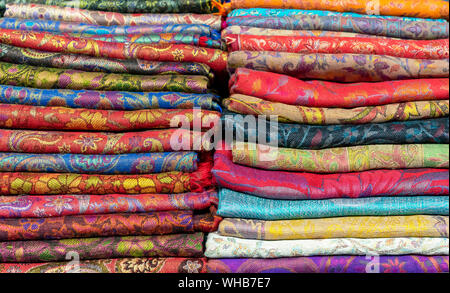 Bright cashmere shawls in the bazaar. Background with oriental shawls. Stock Photo