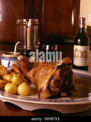 Leg of lamb on a serving platter with veg. Stock Photo