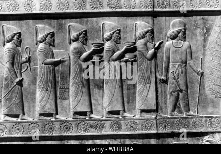 Apadana Palace , Persepolis : Persian relief in sculpture of officials carrying gifts , Iran Stock Photo