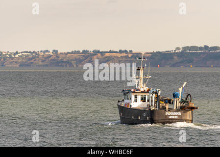 Fishing boat Indianna heading out to sea to fish late afternoon for the night out of Leigh on Sea passing Southend on the Thames Estuary Stock Photo